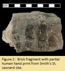 Brick fragment showing four finger impressions.
