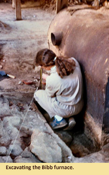 Image of an archaeologist exacating the bibb flue inside the Parran barn.