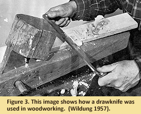 Photo of man using drawknife.